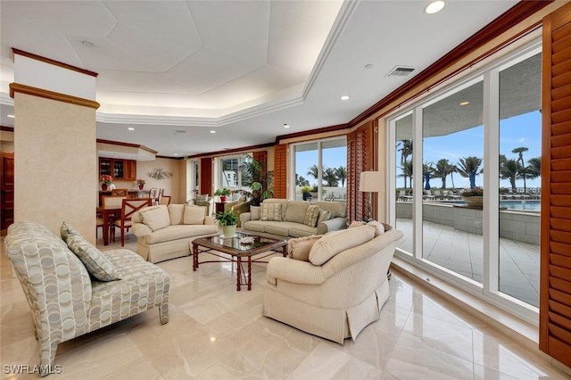 living room with crown molding, a water view, and a tray ceiling