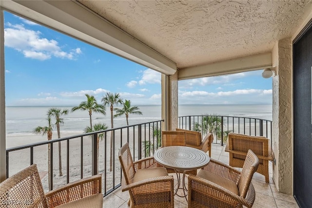 balcony featuring a water view and a beach view