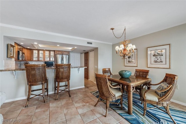 dining room with ornamental molding, light tile patterned flooring, and an inviting chandelier