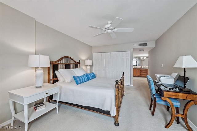 carpeted bedroom with ensuite bathroom, ceiling fan with notable chandelier, and a closet