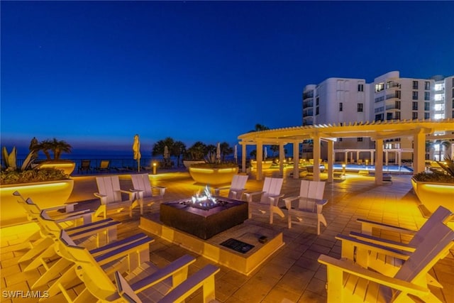 view of patio / terrace with a water view, an outdoor fire pit, and a pergola