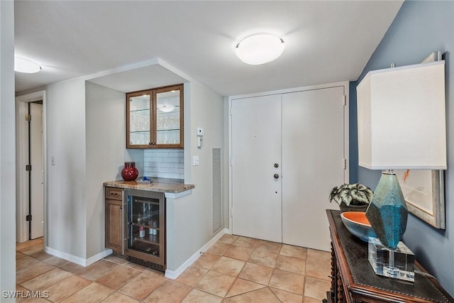 tiled entryway with bar area and beverage cooler