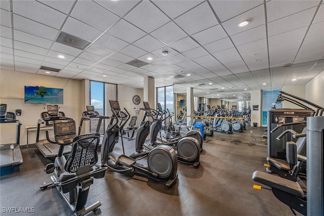 workout area featuring floor to ceiling windows and a paneled ceiling