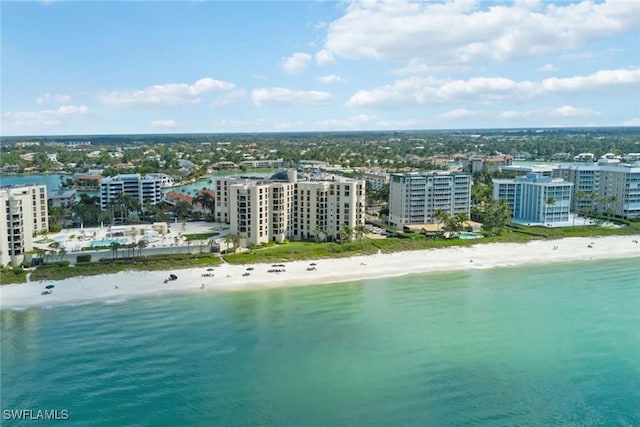 birds eye view of property with a water view and a beach view