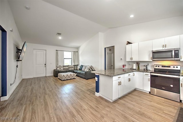 kitchen featuring white cabinetry, kitchen peninsula, appliances with stainless steel finishes, and lofted ceiling