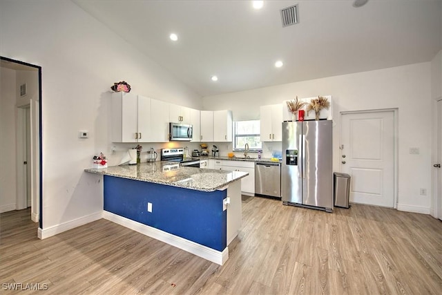 kitchen with kitchen peninsula, light hardwood / wood-style flooring, appliances with stainless steel finishes, white cabinets, and light stone counters