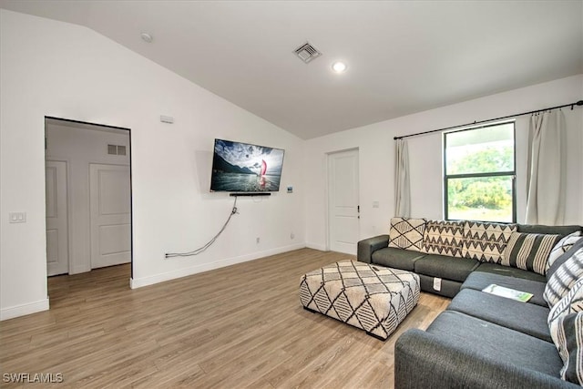 living room featuring light wood-type flooring and vaulted ceiling