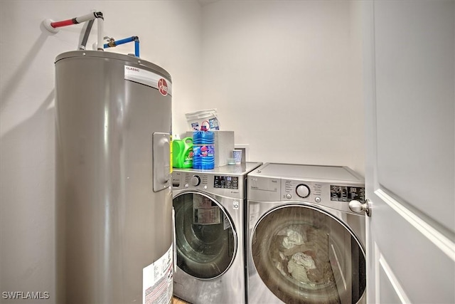 clothes washing area with water heater and washer and dryer