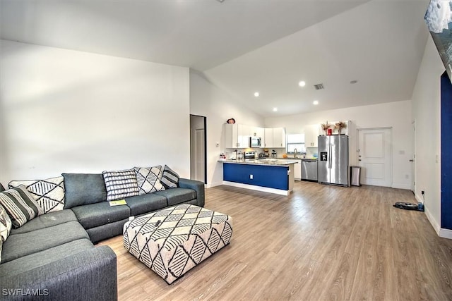 living room featuring lofted ceiling and light wood-type flooring