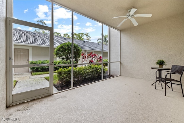 unfurnished sunroom featuring ceiling fan