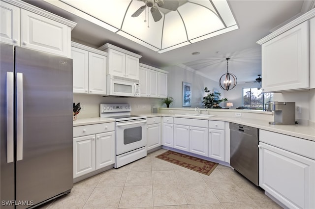 kitchen featuring sink, white cabinetry, appliances with stainless steel finishes, kitchen peninsula, and pendant lighting