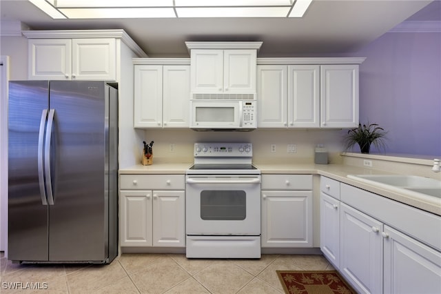 kitchen featuring white cabinetry, sink, and white appliances