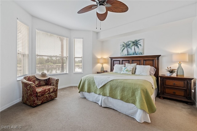 carpeted bedroom featuring multiple windows and ceiling fan