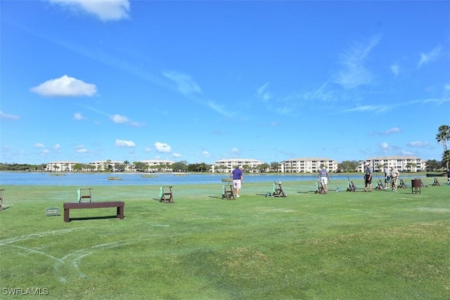 view of property's community featuring a lawn and a water view