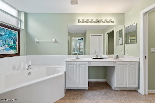 bathroom featuring vanity, tile patterned floors, and a tub