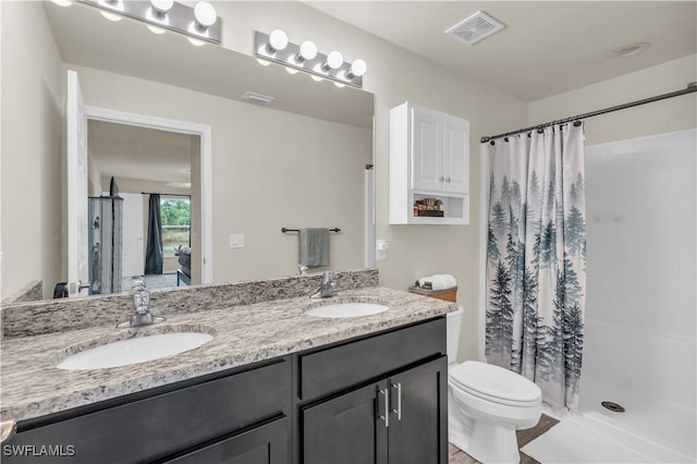 bathroom featuring vanity, toilet, and curtained shower