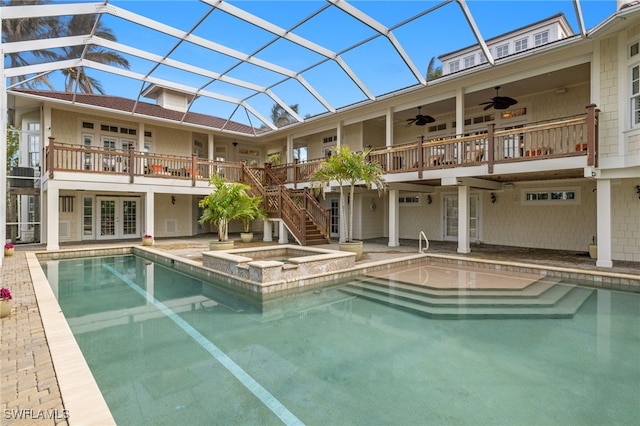 view of swimming pool featuring a lanai, ceiling fan, a patio, french doors, and an in ground hot tub