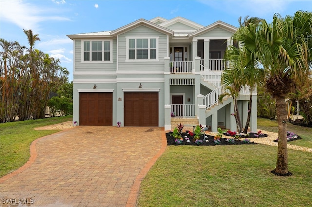 beach home featuring a garage, a front yard, and a sunroom