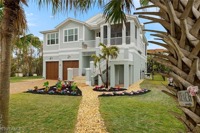 rear view of property with a yard, a garage, and a sunroom