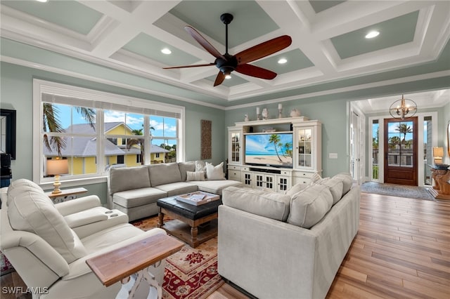 living room with ornamental molding, plenty of natural light, and coffered ceiling