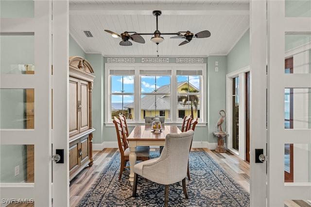 dining area featuring hardwood / wood-style floors, ceiling fan, crown molding, wooden ceiling, and beam ceiling