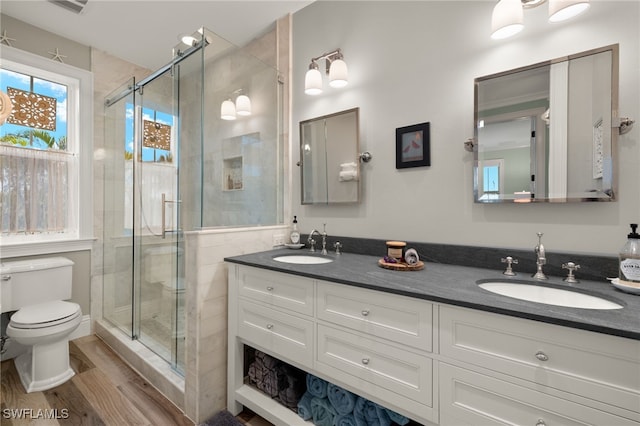 bathroom featuring vanity, toilet, a shower with shower door, and hardwood / wood-style floors