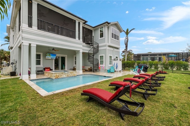 rear view of house featuring a patio, a pool with hot tub, ceiling fan, and a lawn