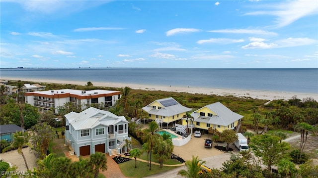 birds eye view of property featuring a water view and a beach view