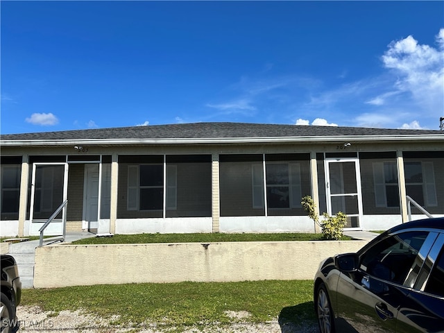 rear view of property featuring a sunroom