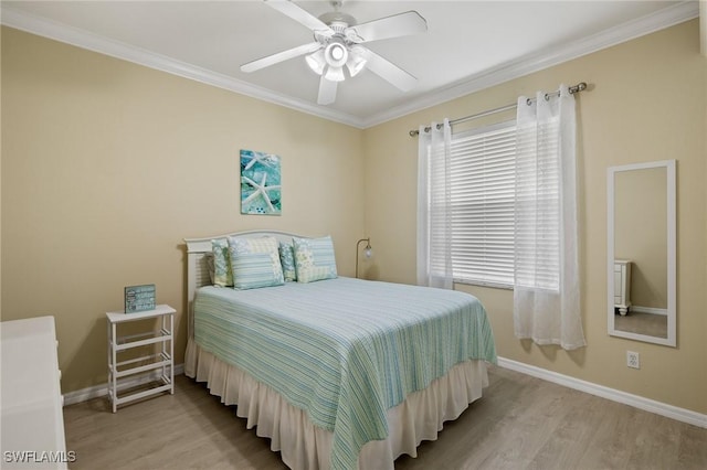 bedroom featuring crown molding, ceiling fan, multiple windows, and light wood-type flooring