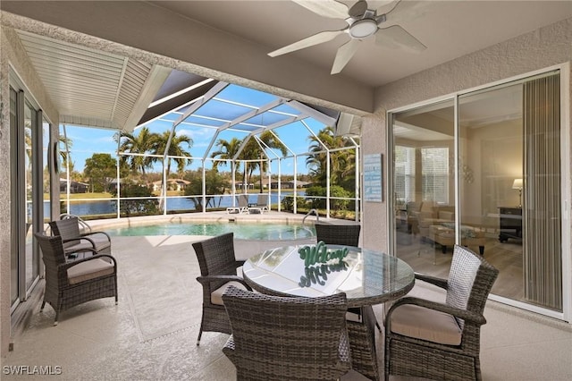 view of patio / terrace with a water view, a lanai, and ceiling fan