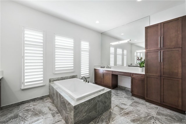 bathroom featuring vanity and tiled bath