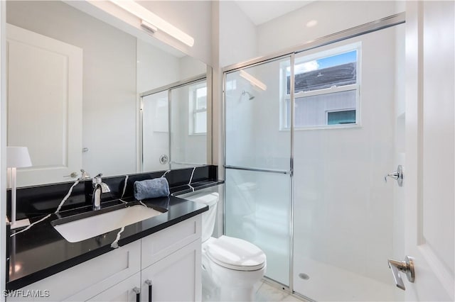 bathroom featuring walk in shower, vanity, and toilet