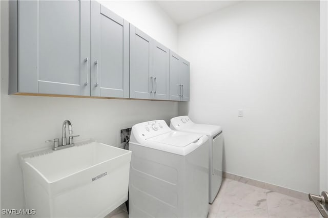 washroom with cabinets, sink, and washing machine and clothes dryer