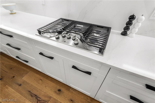 room details with white cabinetry and stainless steel gas stovetop