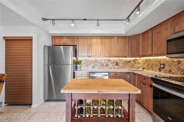 kitchen featuring light tile patterned flooring, appliances with stainless steel finishes, sink, and tasteful backsplash