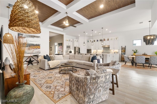 living room with coffered ceiling, light hardwood / wood-style flooring, wooden ceiling, beam ceiling, and ceiling fan with notable chandelier