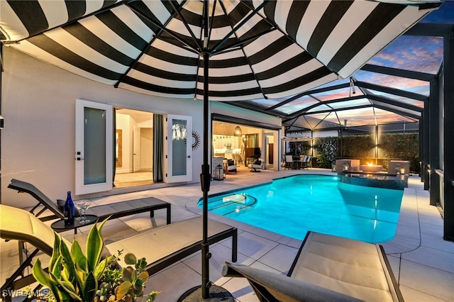 view of swimming pool featuring an in ground hot tub, glass enclosure, and a patio