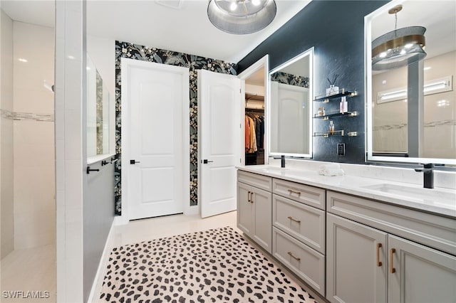 bathroom featuring tiled shower and vanity