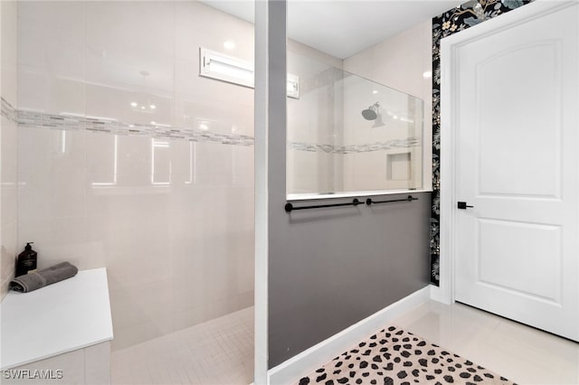 bathroom with a tile shower and tile patterned floors