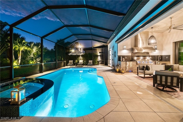 view of swimming pool featuring an outdoor hangout area, a patio, glass enclosure, and an outdoor kitchen