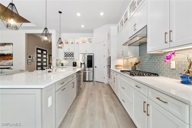 kitchen with sink, white cabinetry, decorative light fixtures, a center island with sink, and appliances with stainless steel finishes