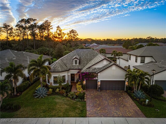 view of front of property with a garage and a lawn