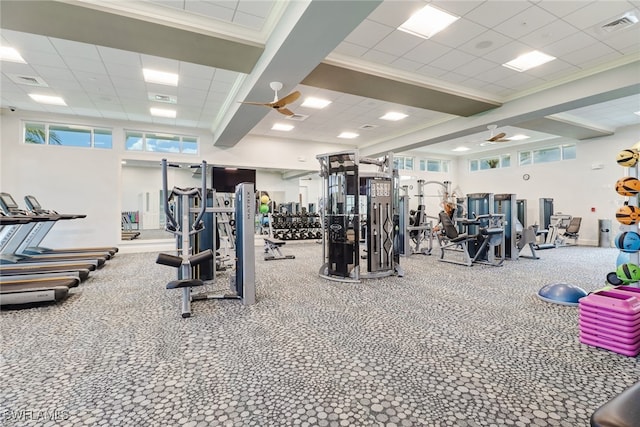 exercise room featuring a paneled ceiling, ornamental molding, and ceiling fan