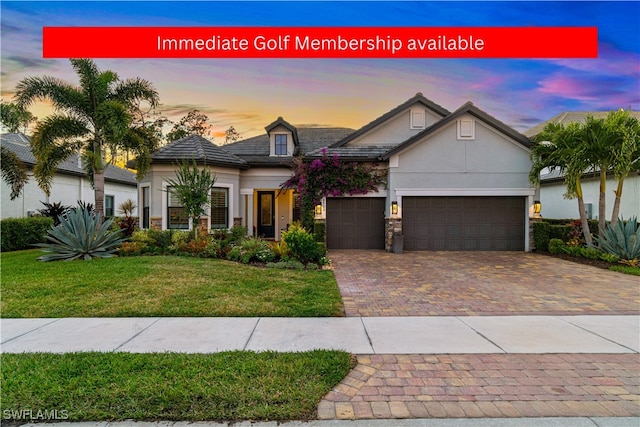 view of front of house featuring a garage and a lawn