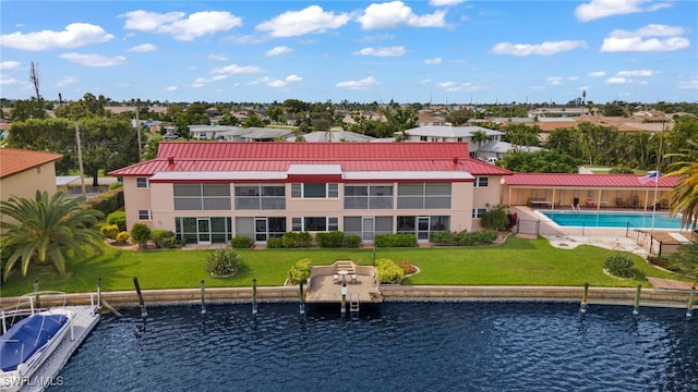 rear view of property with a yard and a water view