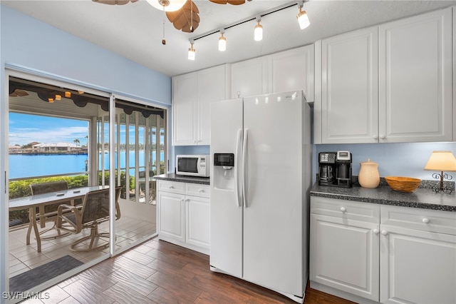 kitchen with white cabinetry, white appliances, ceiling fan, and a water view