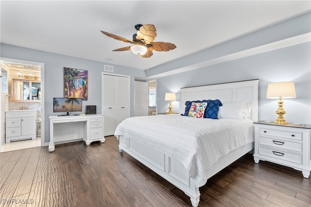 bedroom with ensuite bathroom, dark hardwood / wood-style floors, ceiling fan, a textured ceiling, and a closet