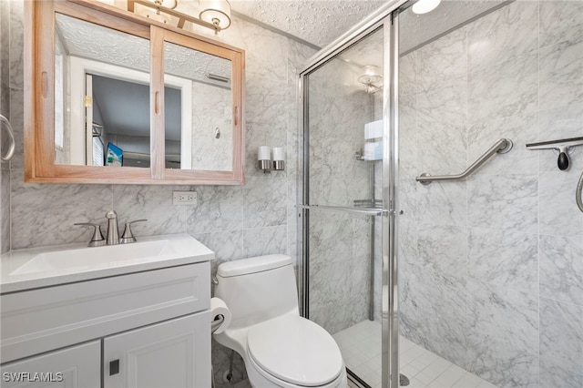 bathroom with vanity, toilet, a shower with shower door, and tile walls