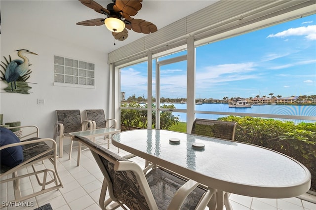 sunroom / solarium with a water view and ceiling fan